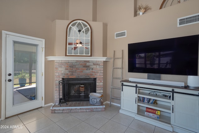 tiled living room with a high ceiling and a fireplace