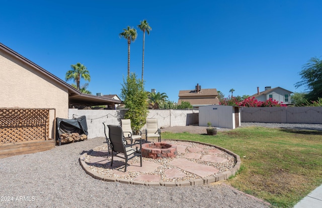 view of yard with a storage shed, a patio area, and an outdoor fire pit