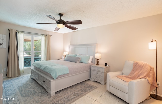 bedroom featuring a textured ceiling, light tile patterned floors, and ceiling fan