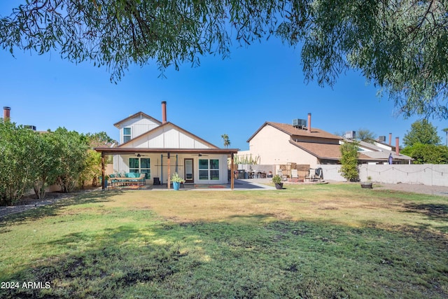 back of property with a patio, a lawn, and cooling unit