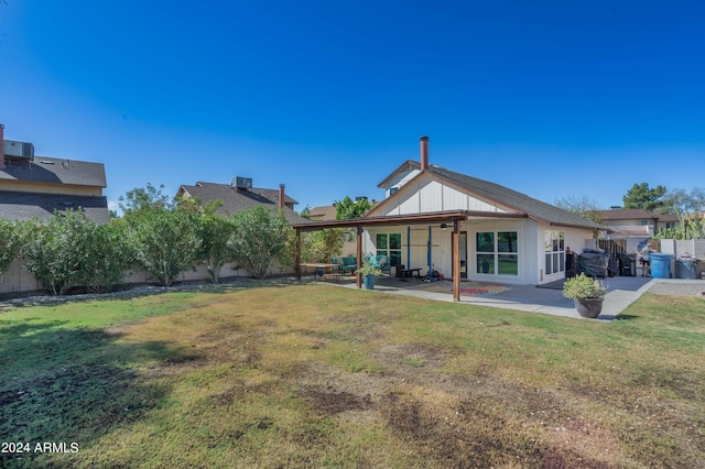 rear view of property featuring a yard and a patio