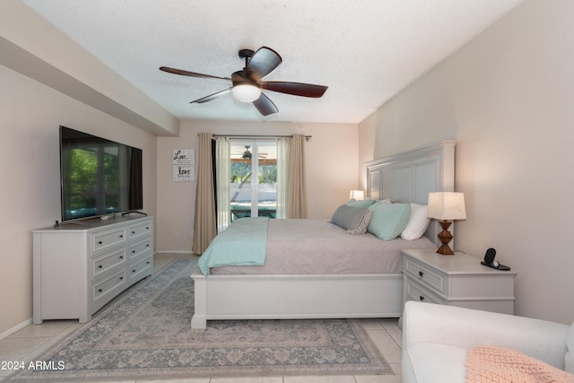 bedroom featuring access to exterior, a textured ceiling, light tile patterned floors, and ceiling fan