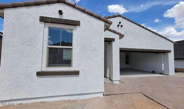 exterior space with stucco siding and a tile roof