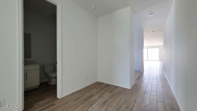 hallway featuring baseboards and wood finished floors