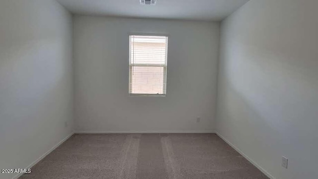 unfurnished room with visible vents, baseboards, and carpet flooring