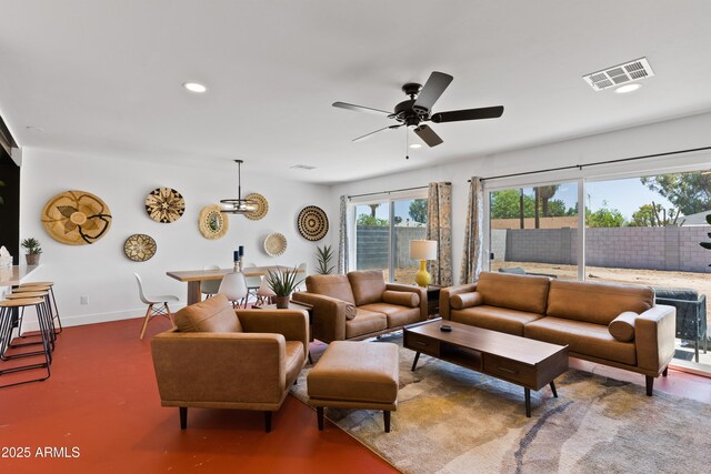 living room featuring ceiling fan with notable chandelier