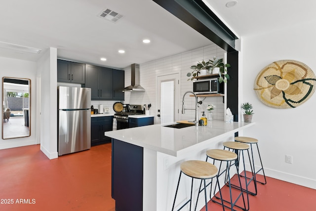 kitchen featuring stainless steel appliances, a kitchen bar, kitchen peninsula, and decorative backsplash