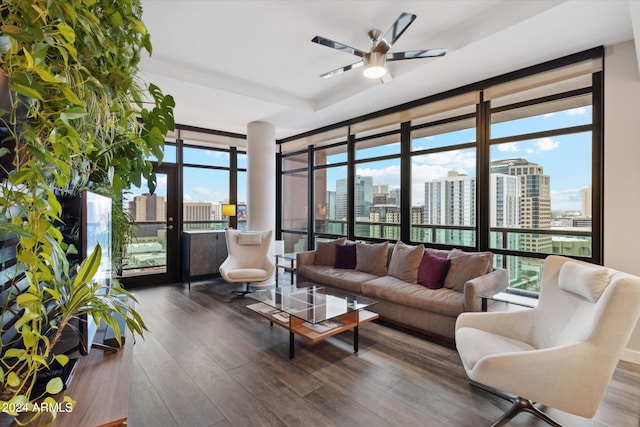 living room with ceiling fan, expansive windows, and dark hardwood / wood-style flooring