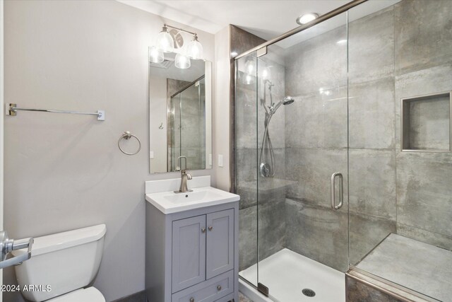 bathroom featuring vanity, toilet, and an enclosed shower