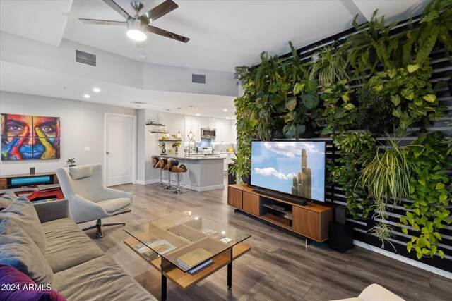 living room with wood-type flooring, ceiling fan, and sink