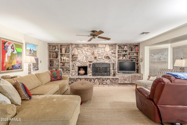 living room featuring ceiling fan and a fireplace