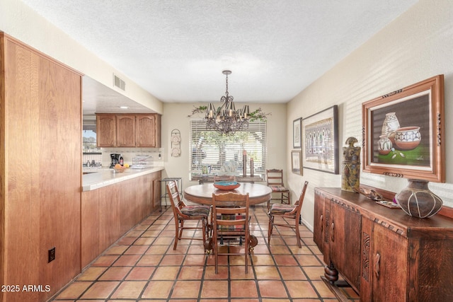 dining room with light tile patterned floors, a textured ceiling, and a chandelier