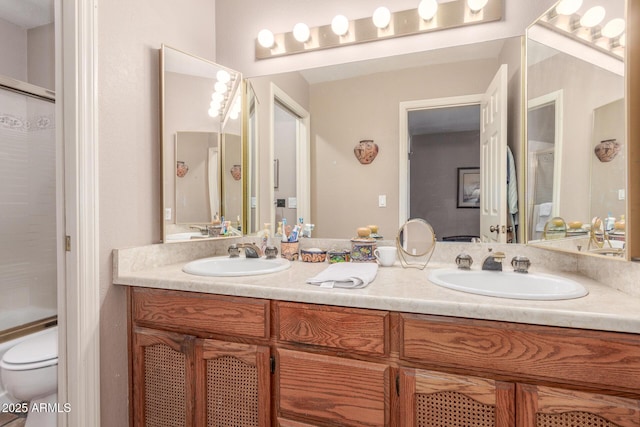 full bathroom featuring vanity, bath / shower combo with glass door, and toilet