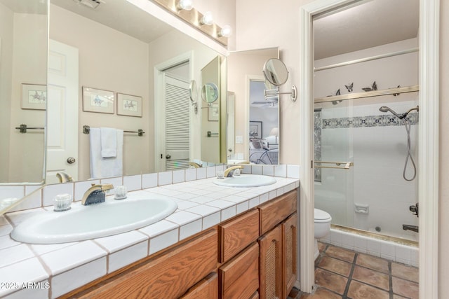 bathroom with vanity, tile patterned flooring, a shower with shower door, and toilet