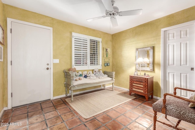 sitting room featuring tile patterned floors and ceiling fan