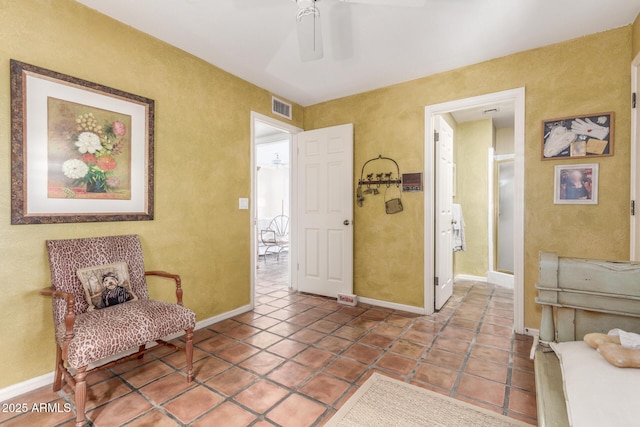 sitting room featuring tile patterned flooring and ceiling fan