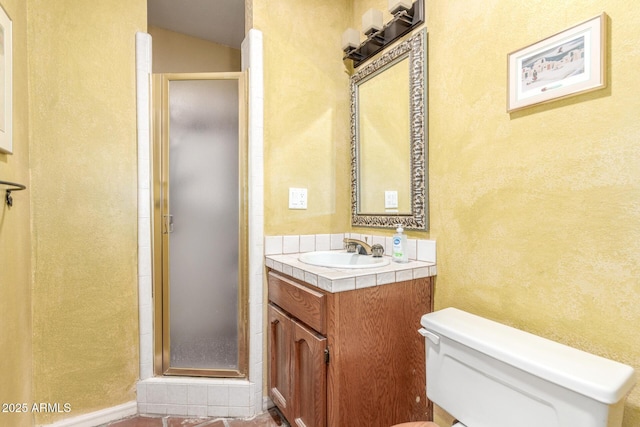 bathroom with vanity, toilet, and a shower with door