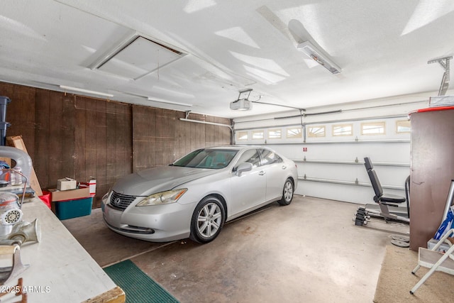 garage featuring a garage door opener and wood walls