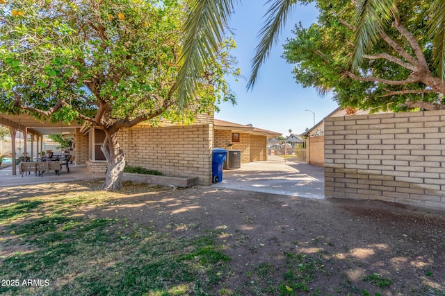 view of property exterior featuring cooling unit and a patio area