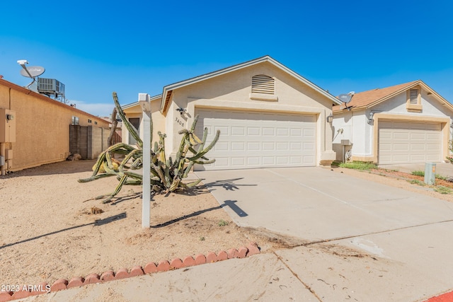 ranch-style home featuring a garage and central AC unit