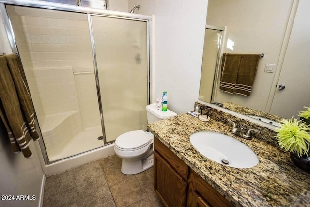 bathroom featuring tile patterned floors, vanity, toilet, and walk in shower