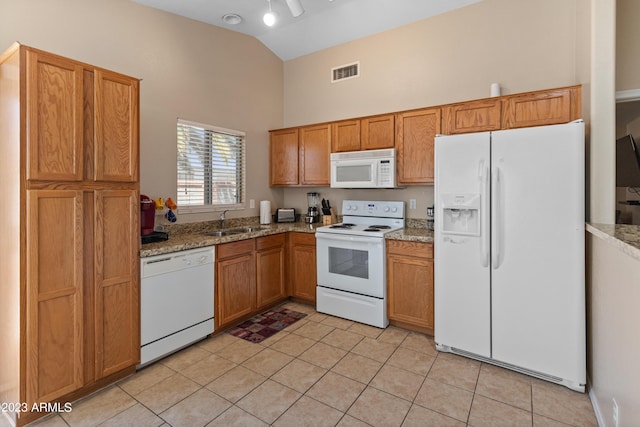 kitchen with light stone counters, sink, light tile patterned floors, and white appliances