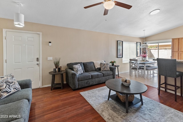 living room featuring lofted ceiling, ceiling fan, a textured ceiling, and dark hardwood / wood-style floors