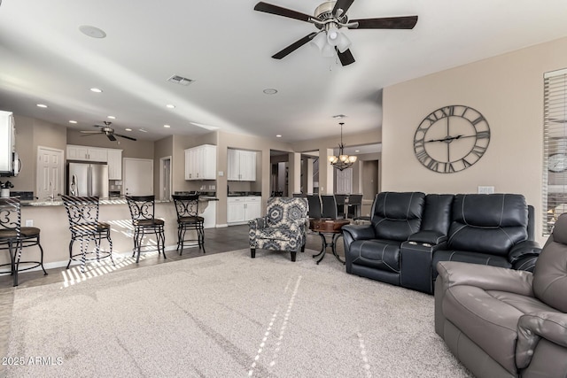 living room featuring ceiling fan with notable chandelier