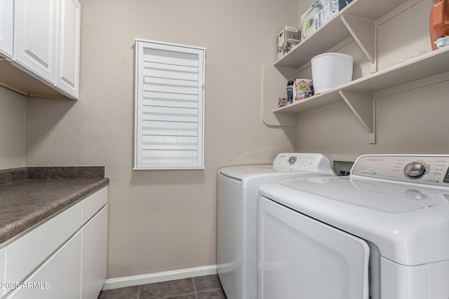 laundry area featuring cabinets, independent washer and dryer, and dark tile patterned floors