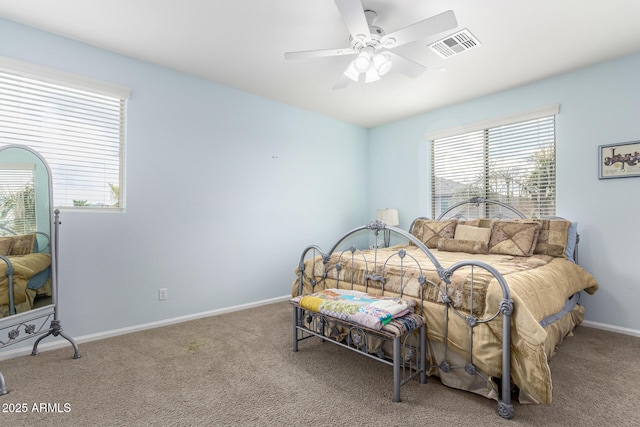 carpeted bedroom with ceiling fan and multiple windows