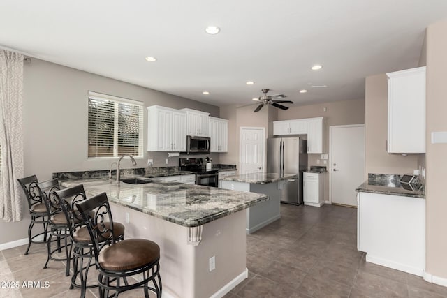 kitchen with a breakfast bar, sink, white cabinets, kitchen peninsula, and stainless steel appliances