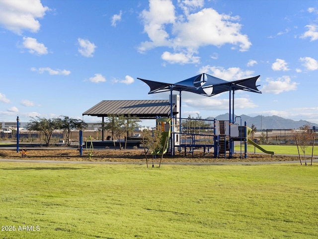 view of playground featuring a mountain view and a lawn