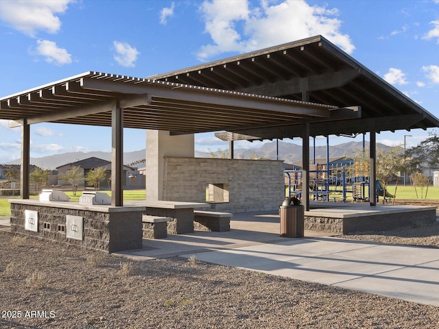 surrounding community with a mountain view and exterior kitchen