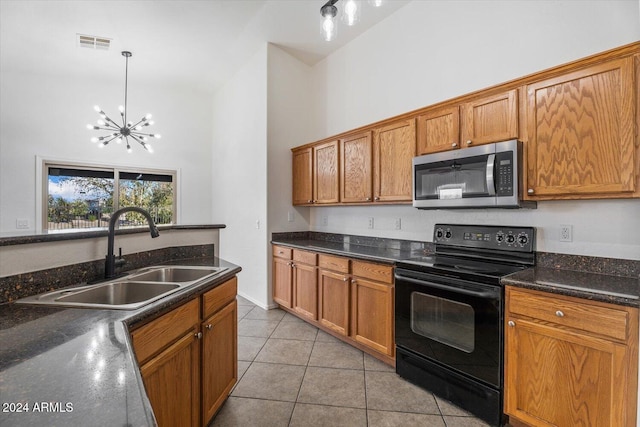 kitchen with pendant lighting, high vaulted ceiling, sink, electric range, and light tile patterned floors