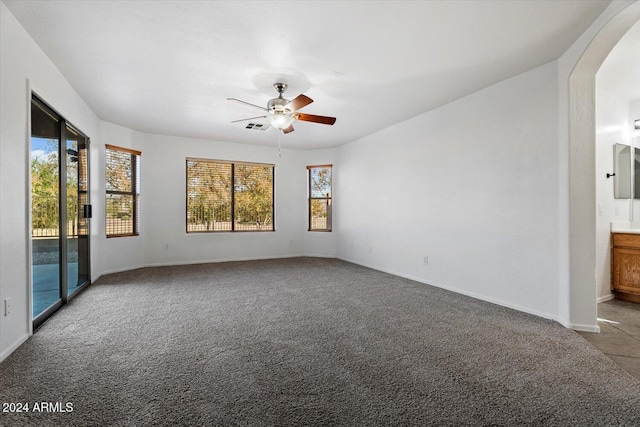 carpeted spare room with plenty of natural light and ceiling fan