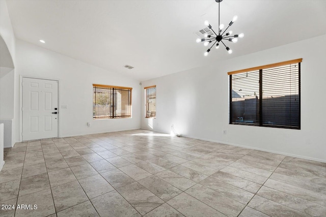 tiled empty room featuring a chandelier and lofted ceiling