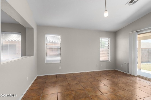 tiled spare room with vaulted ceiling