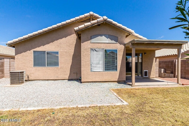 rear view of property featuring a lawn, central air condition unit, and a patio