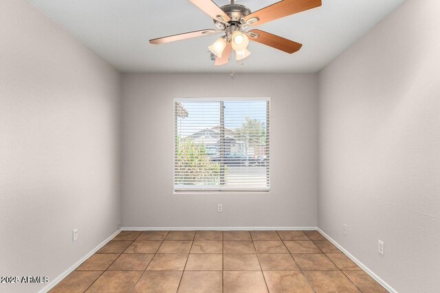 tiled spare room with ceiling fan