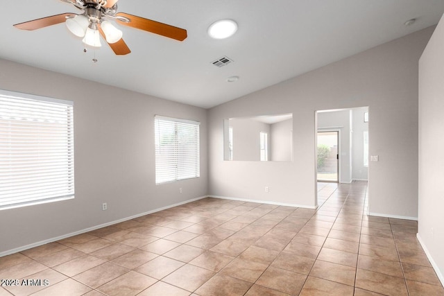 unfurnished room featuring ceiling fan, plenty of natural light, light tile patterned floors, and vaulted ceiling