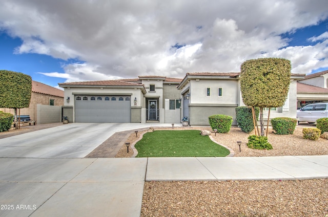 view of front of property featuring a garage, concrete driveway, a tiled roof, and stucco siding