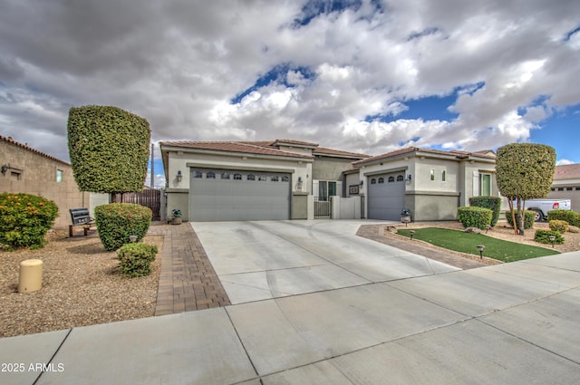 view of front of home with a tile roof, driveway, an attached garage, and stucco siding