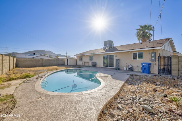 view of swimming pool with cooling unit and a patio