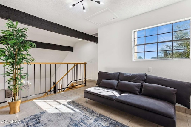 living room with attic access, tile patterned flooring, beamed ceiling, and a textured ceiling