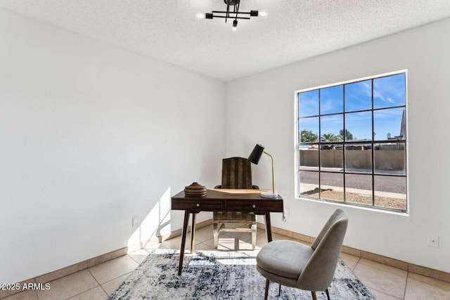 office space featuring light tile patterned floors, a textured ceiling, and baseboards