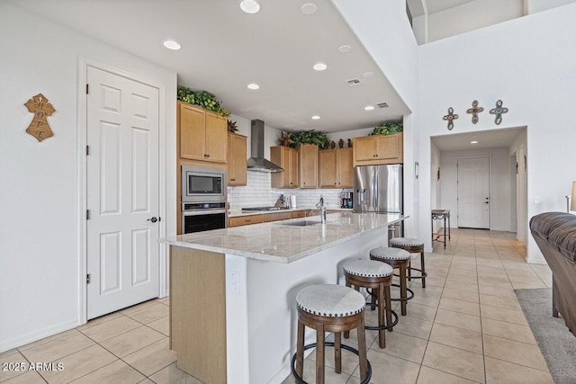 8521 S 67th Dr, Laveen, AZ 85339 - kitchen with backsplash, wall chimney exhaust hood, a kitchen breakfast bar, appliances with stainless steel finishes, and light tile patterned floors
