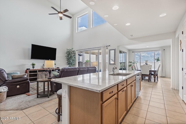 8521 S 67th Dr, Laveen, AZ 85339 - kitchen with light stone counters, a sink, open floor plan, light tile patterned floors, and a kitchen island with sink