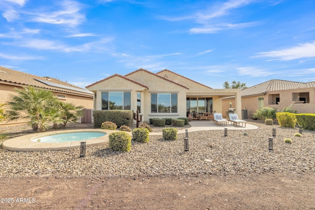 back of house with a patio area and a hot tub