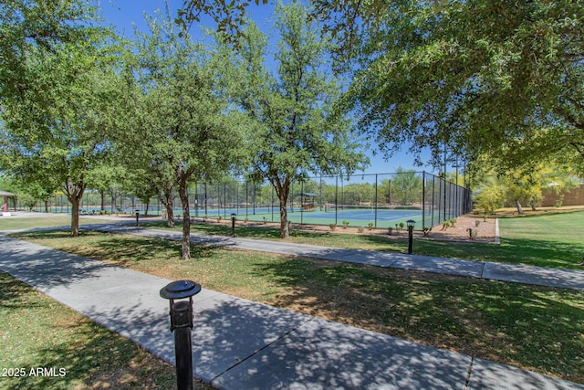 view of community with a yard and tennis court