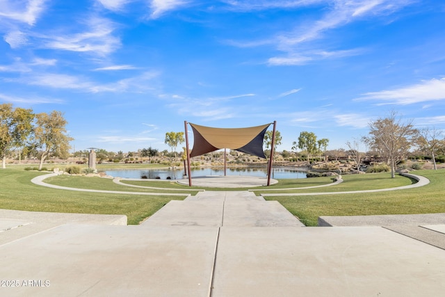 view of home's community with a water view and a yard